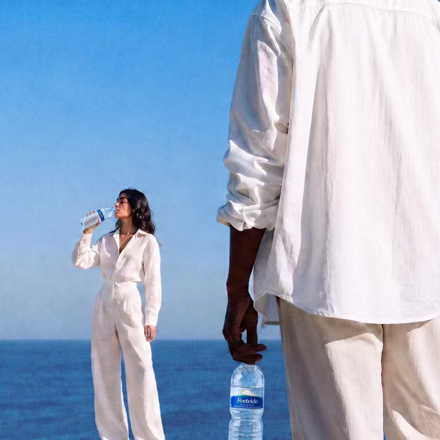 Dos personas con botellas de Fonteide junto al mar en Tenerife